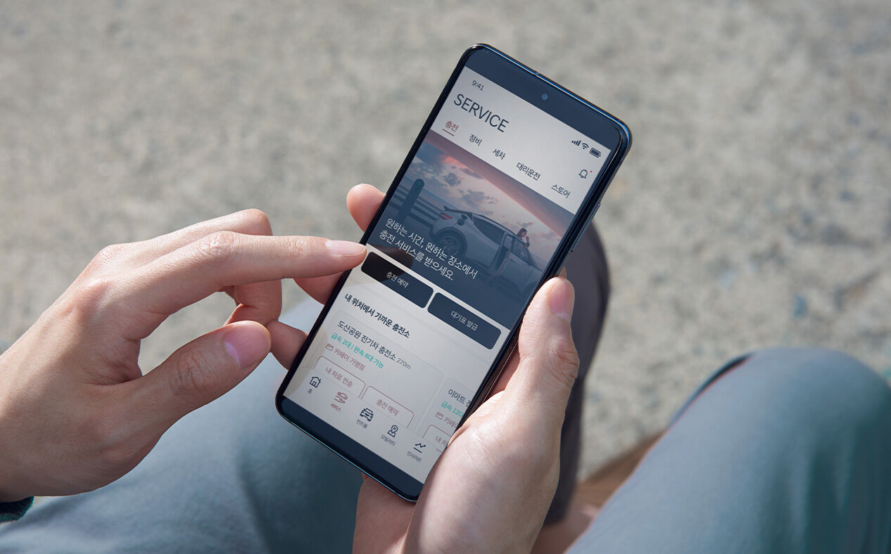 A person is using the dedicated Genesis app on a smartphone.