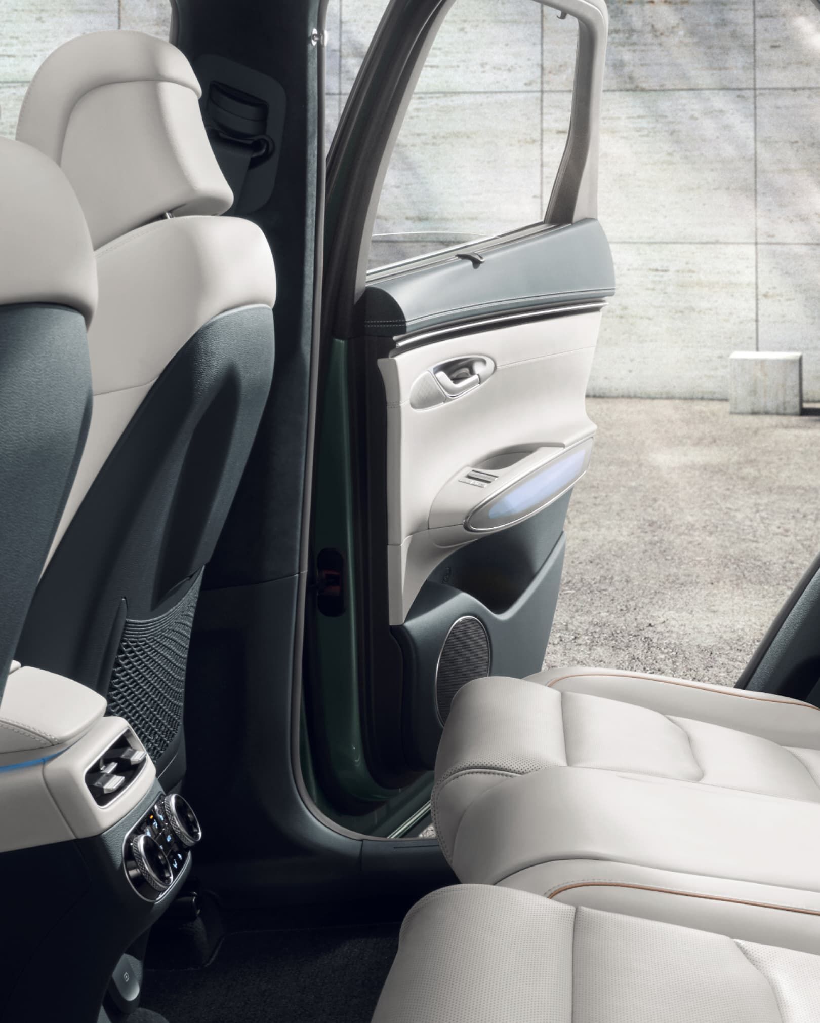 The cream and natural colored 2nd-row space looks comfortable. The right back door is open. 