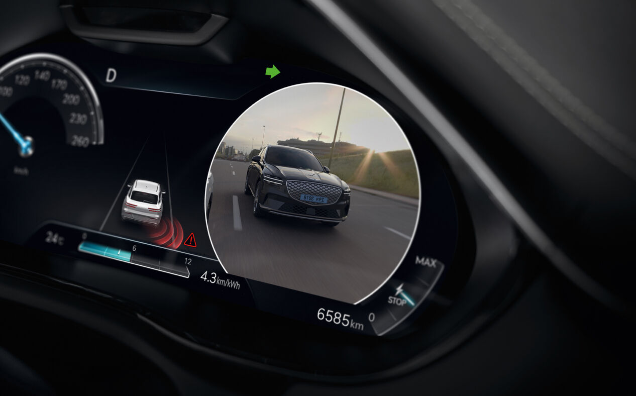 The cluster shows a car behind on the Blind-Spot View Monitor.