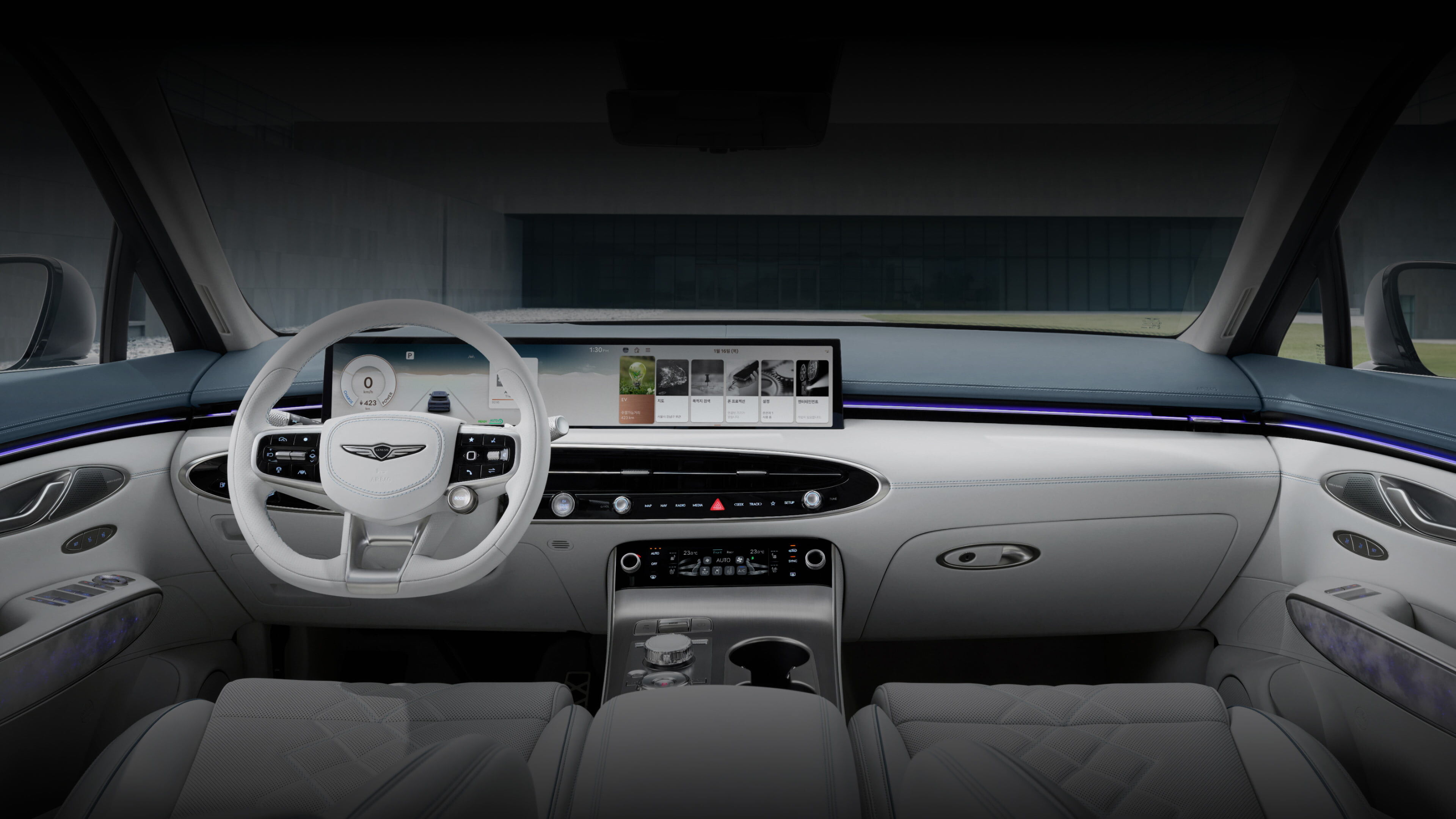 A detailed view of the driver and front passenger seats of the Electrified GV70, including a variety of buttons near the door handle as well as the steering wheel, display screen, and a cluster of control buttons between the driver and front passenger seats. 