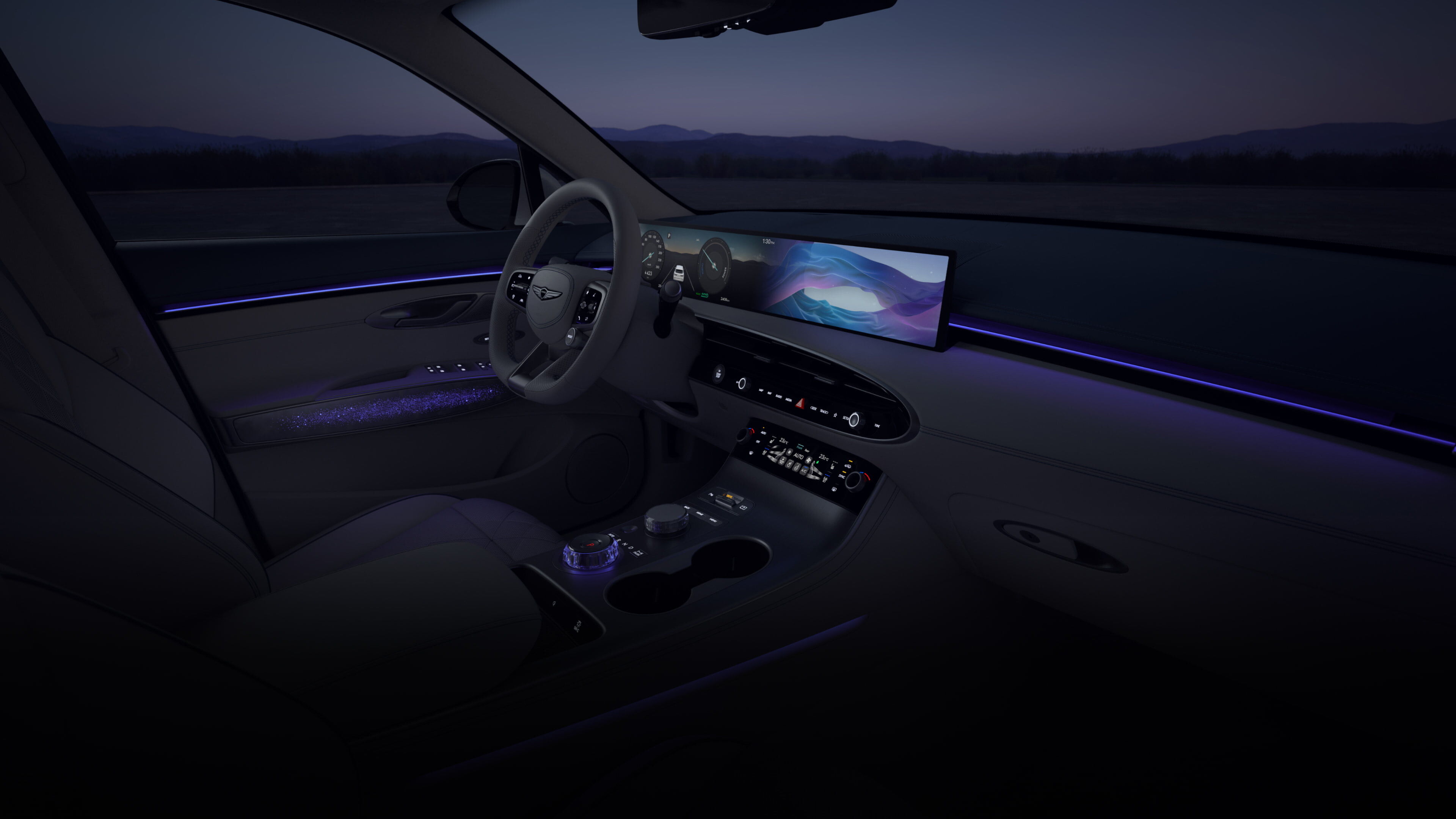 A wide-angle view of the driver's seat from the front passenger's seat. A vibrant array of colorful graphics cycle on the wide display screen in front of the driver’s seat. As the colors on the display shift, so does the ambient lighting of the vehicle's interior. 