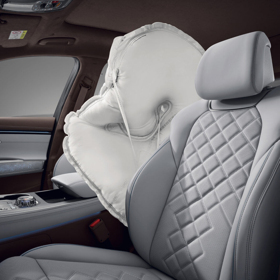 A white airbag is deployed between the driver and front passenger seats.