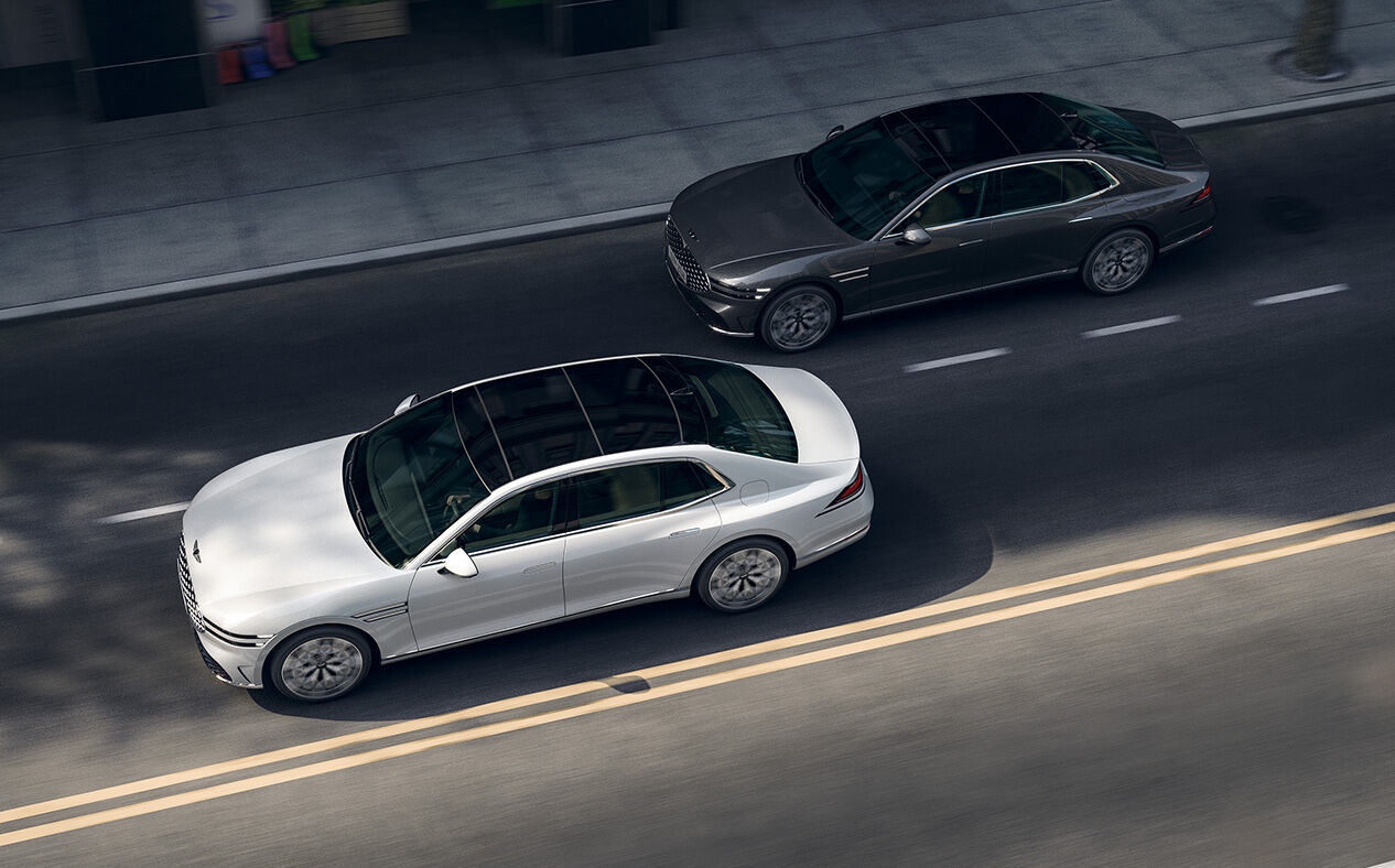 A G90 in Uyuni White and a G90 in Makalu Gray are driving.