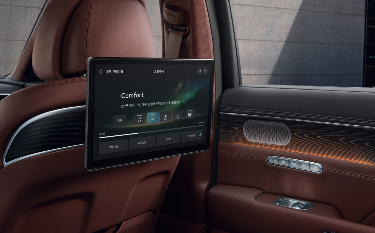 Orange lights are illuminated on the second row dual monitors and the vehicle door inside Bordeaux Brown interior.
