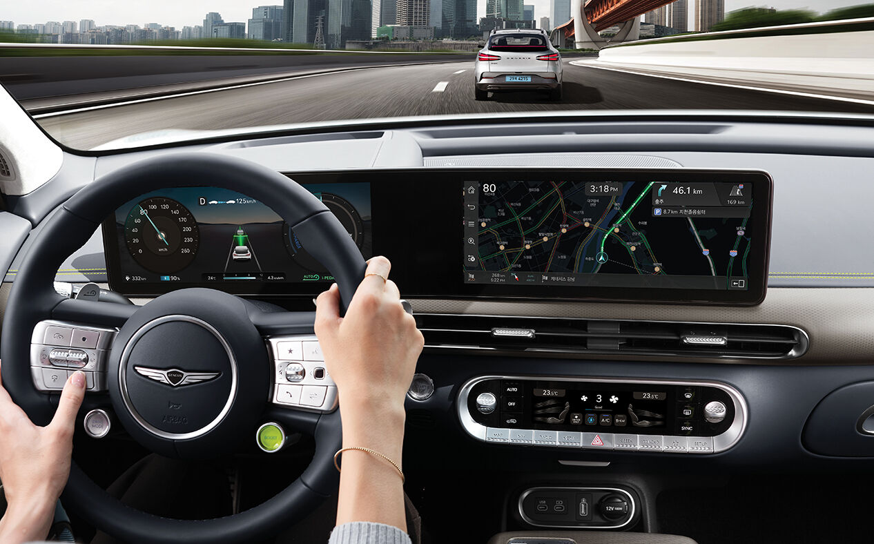 A driver driving on the highway and the Infotainment System.