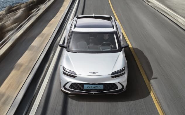 You can see the front of the GV60 driving on the highway.