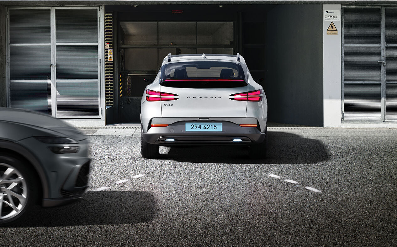 A vehicle reversing and another vehicle approaching from the left.