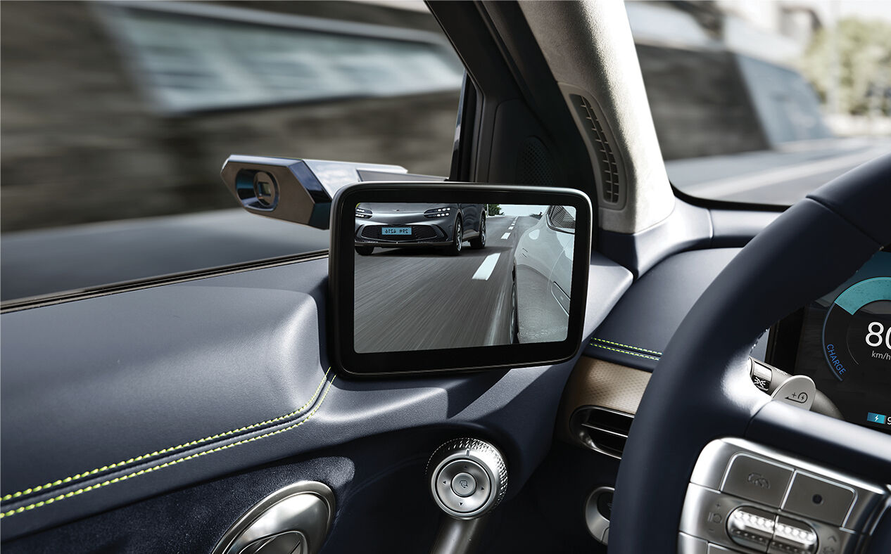 Other vehicles are seen driving behind GV60 in the digital side mirrors.