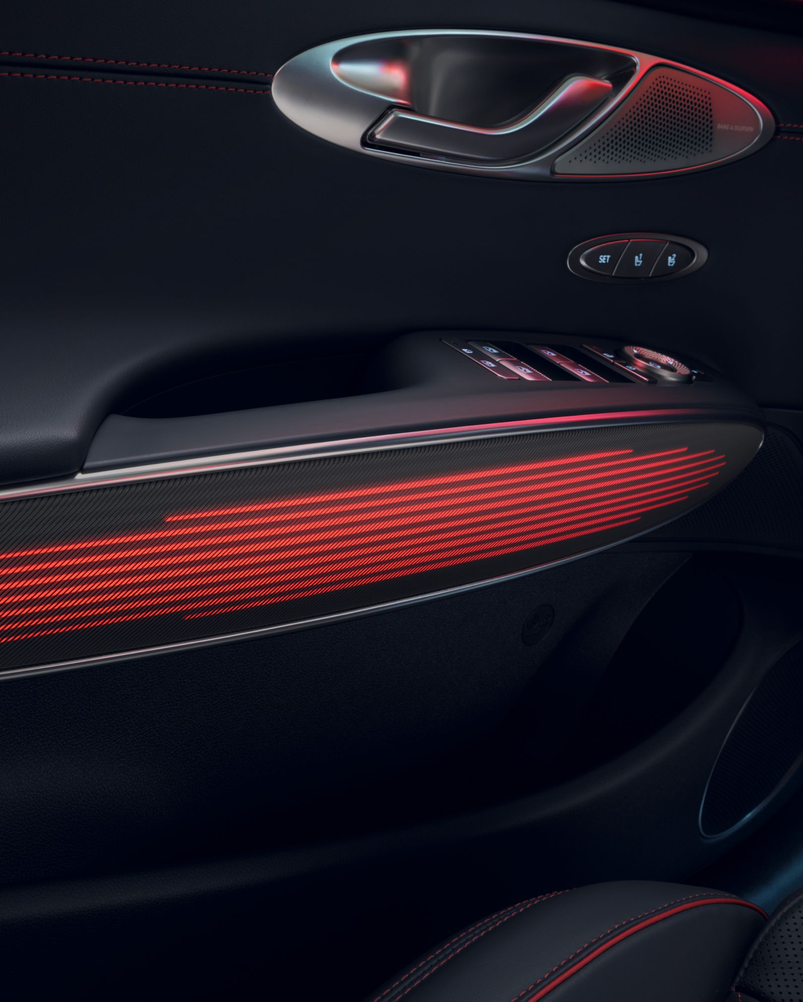 You can see the mood lighting in red on the interior door handle of the GV70 Sports Package. Above it are the door handle for opening and various control buttons.