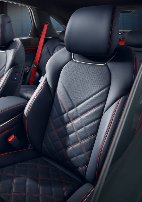 The orange stitching and black leather-designed seats of the  GV70 Sports Package are highlighted.
