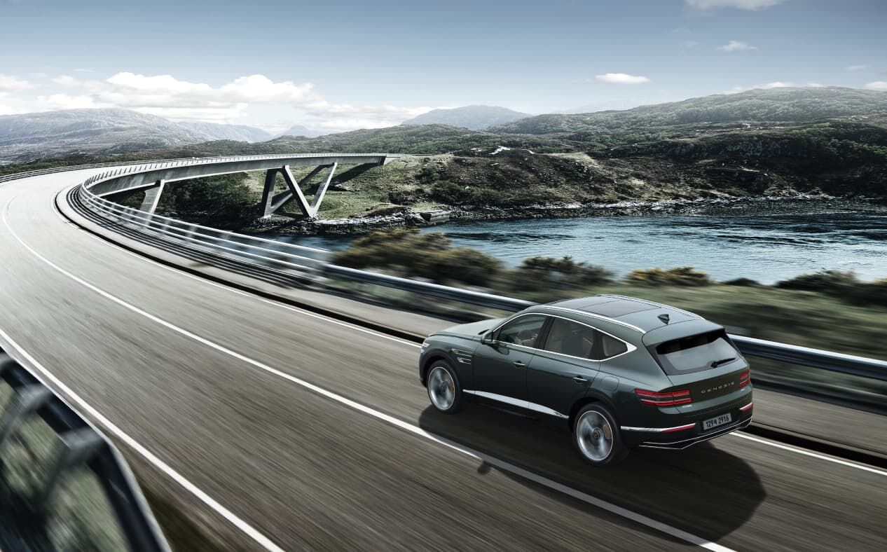 Storr Green GV80 driving fast on the highway while maintaining a safe distance from the vehicle in front.