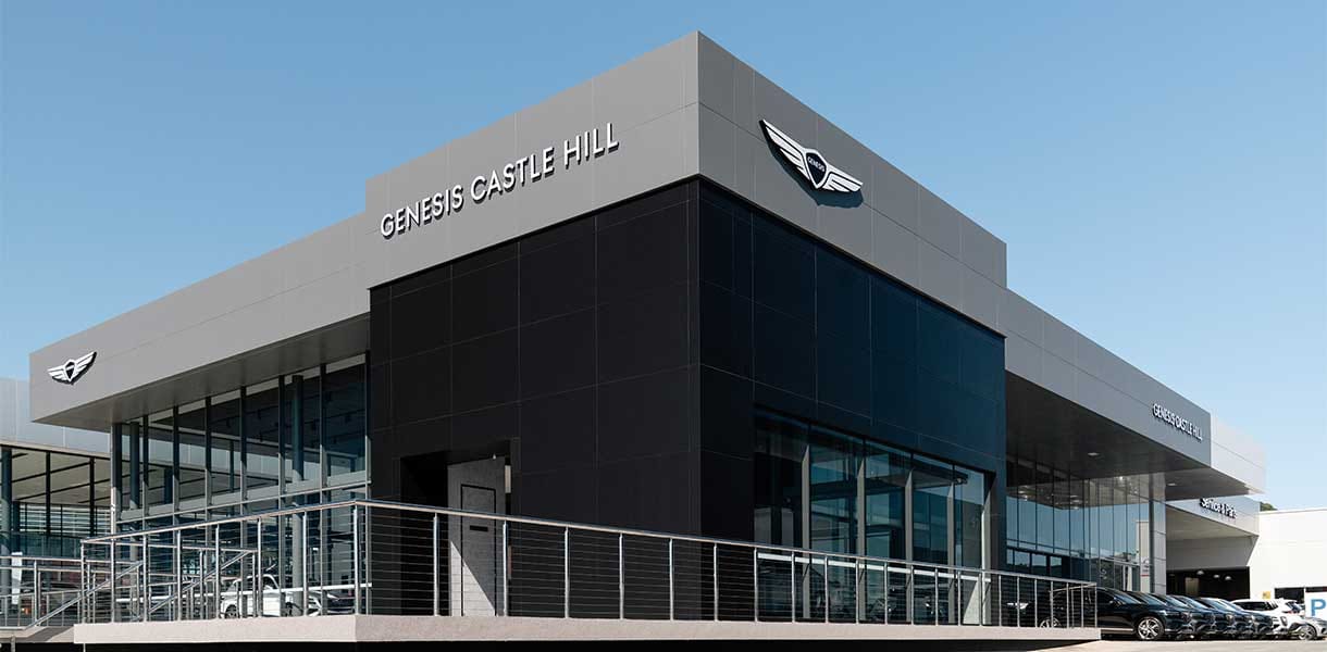 Exterior view of Genesis Castle Hill dealership featuring sleek architecture, expansive glass panels, and premium Genesis branding showcasing modern luxury and automotive elegance in Sydney.