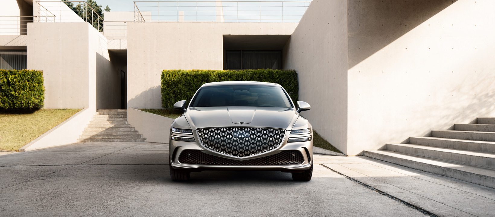 a low angle image of the car focusing on the emblem's crest which sits on the distinct genesis grill