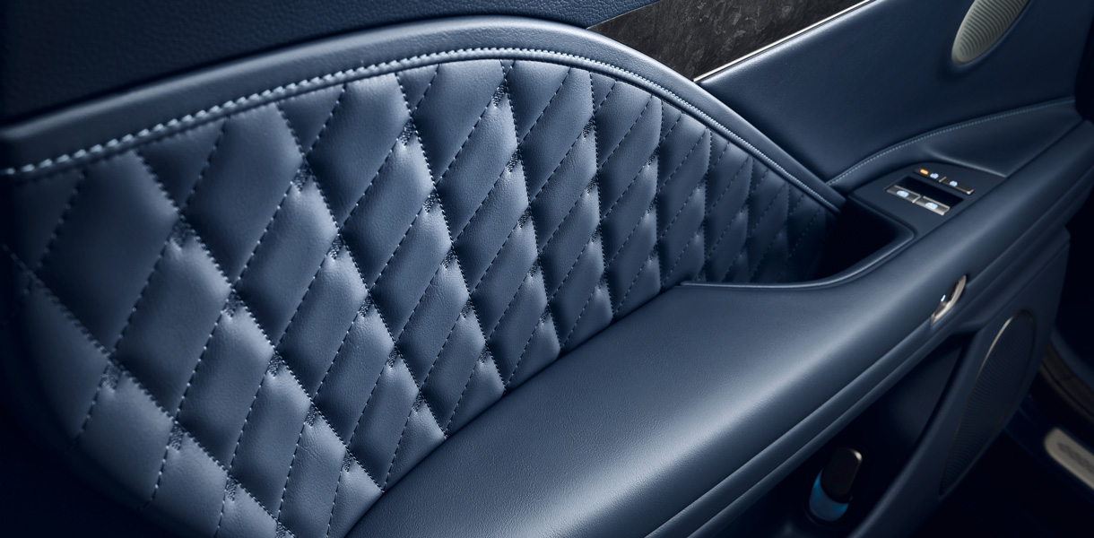 The quilted pattern, flowing from the seating, seamlessly blends into the door trim, enhancing the premium experience of a luxury electric sedan.