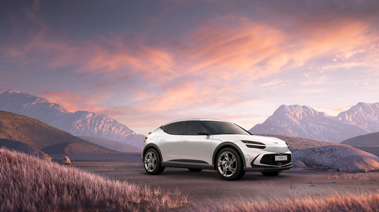 rear angle shot of white GV60 parked on a cliff edge overlooking mountainous terrain