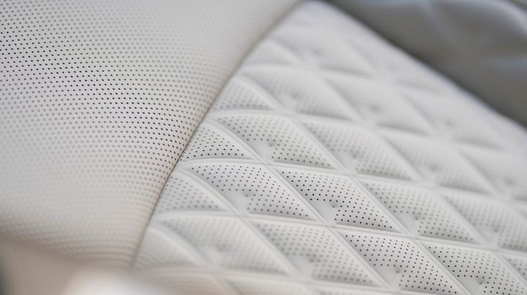 Interior shot of GV60 interior light beige leather seating with close up on leather stitching