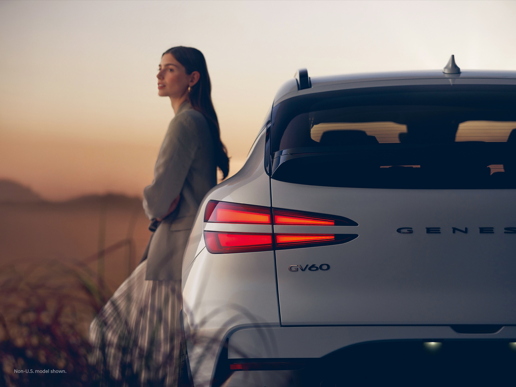 2023 Genesis GV60 at dusk with rear taillights illuminated.
