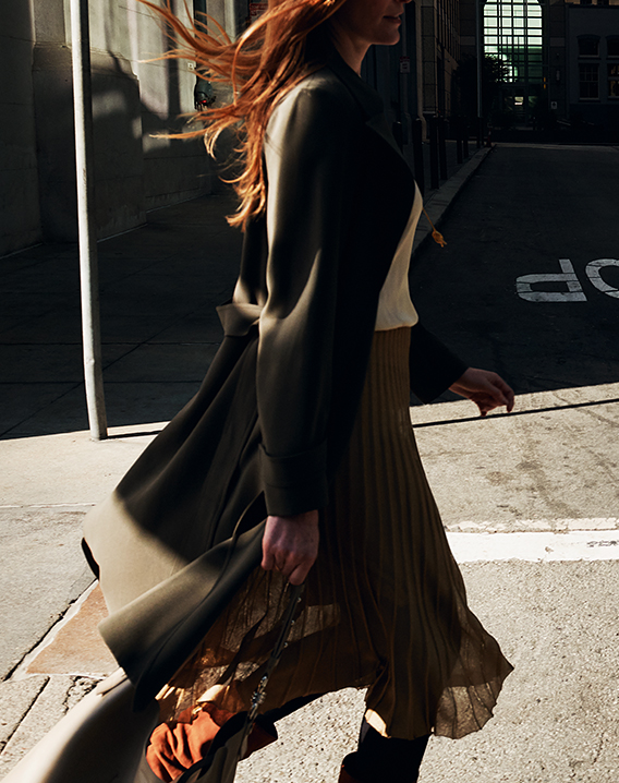 a girl walking on the sidewalk next to the parking sign