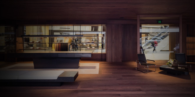 interior of Melbourne genesis studio in lowlighting and furnished with wooden seating and interior walls 
