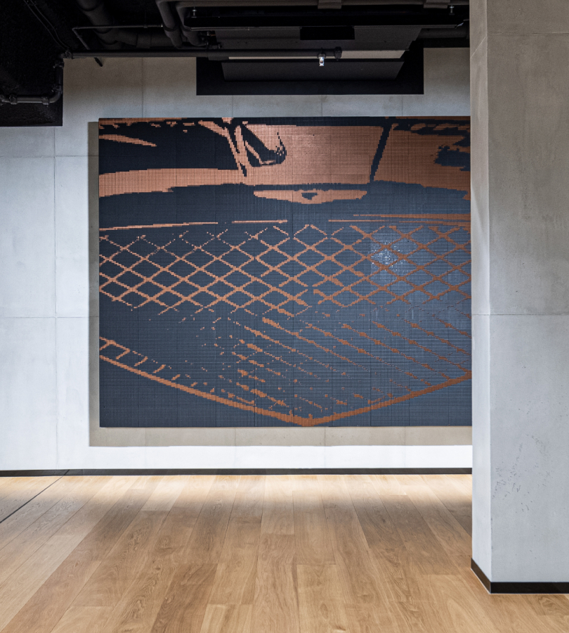 A large drawing of a Genesis vehicle's front grill hangs on the wall.