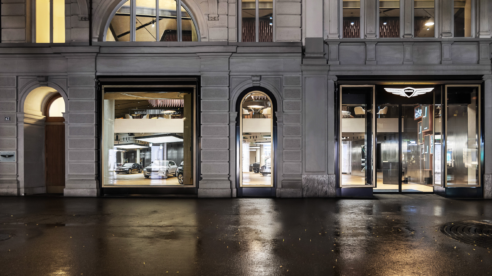 An exterior view of Genesis Studio Geneva, located on the first floor. Floor-to-ceiling windows show Genesis vehicles on display inside.