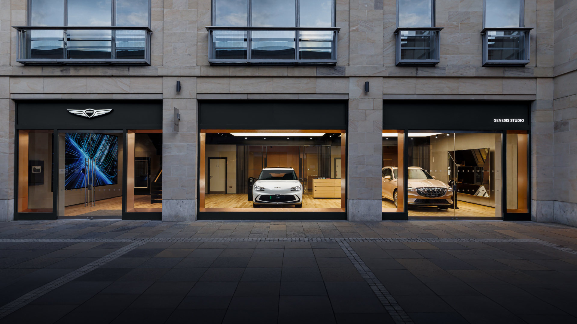 An exterior view of Genesis Studio Edinburgh, located on the first floor. Floor-to-ceiling windows show Genesis vehicles on display inside.