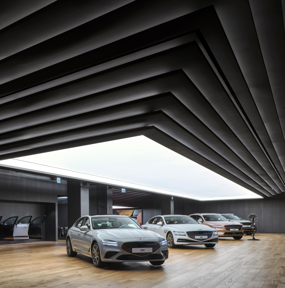 Inside Genesis Studio Anseong, four Genesis vehicles are on display underneath a large light.